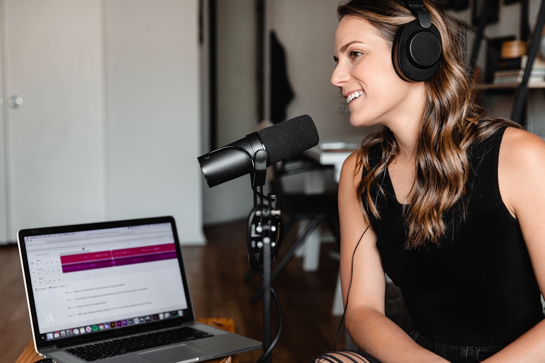 A creator recording in a home studio, headphones on, mid-performance